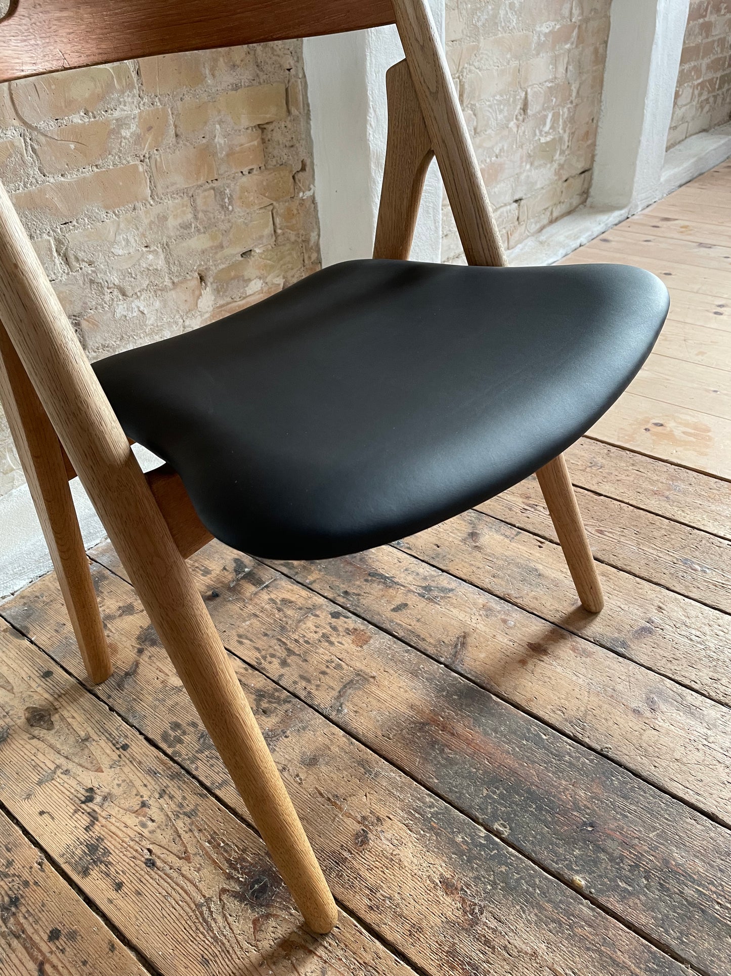 Wegner savbukkestol ompolstret I sort læder